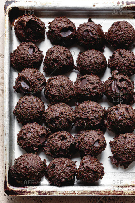 Scoops of double chocolate ginger cookie dough on a baking tray.