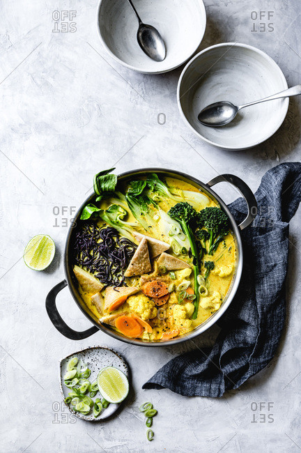 Thai curry with black rice noodles, tofu, carrot, broccolini, bok choy, cauliflower, lime, scallions