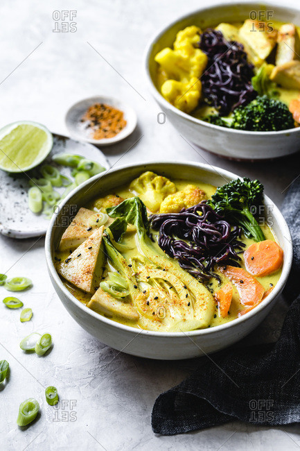 Thai curry with black rice noodles, tofu, carrot, broccolini, bok choy, cauliflower, lime, scallions