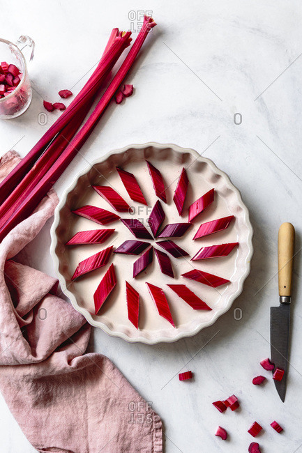 Rhubarb pieces in a pattern on the base of a baking dish.