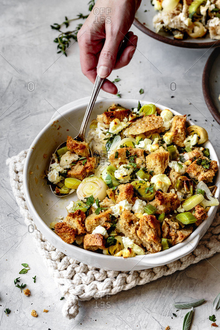Leek and goat cheese stuffing on a hand held spoon.