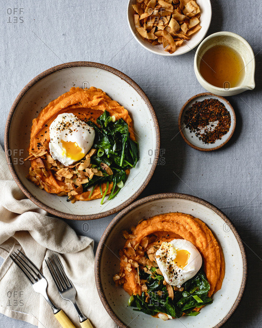 Sweet potato breakfast bowls with spinach, coconut bacon, a poached egg and sesame oil.