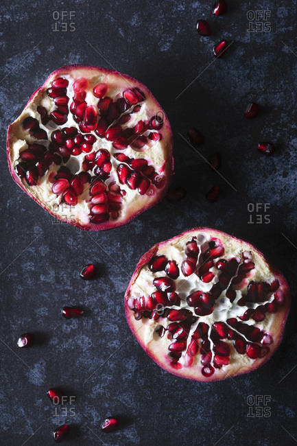 Two pomegranate halves on a dark blue background.