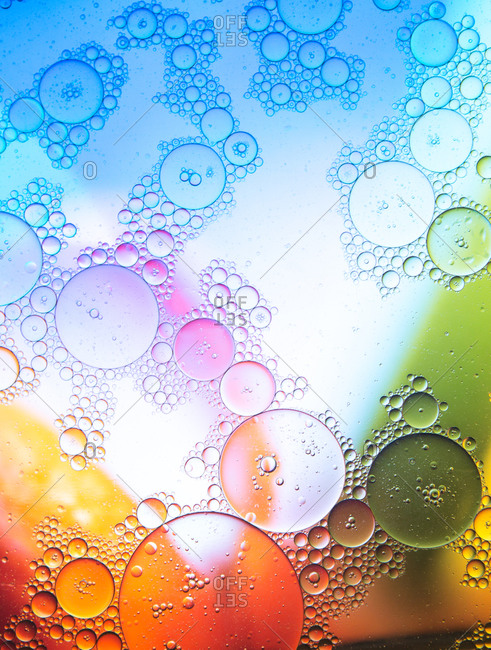Top view of transparent soap bubbles covering colorful background with vivid geometric stains