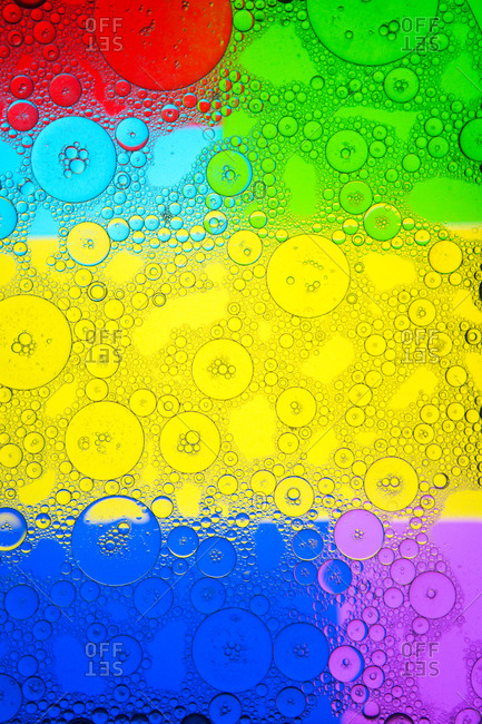 Top view of transparent soap bubbles covering colorful background with vivid geometric stains