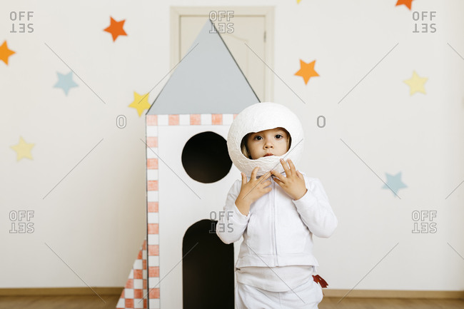 Girl wearing costume and playing astronaut at rocket