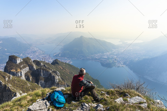 Rear view of hiker sitting on mountaintop- Orobie Alps- Lecco- Italy