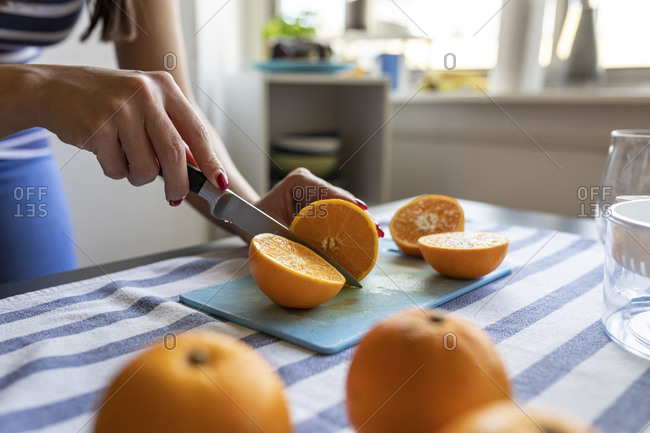 Woman slicing fresh oranges for freshly squeezed orange juice