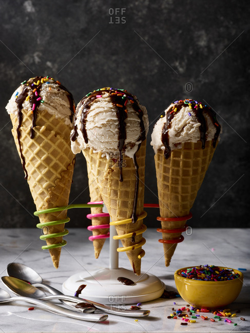 Ice cream cones with fudge and sprinkles in a cone stand