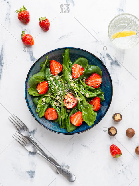 Strawberry salad with spinach, nuts, sesame seeds and green leaf cress salad