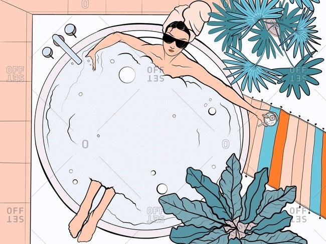 Young stylish girl in sunglasses is resting in a foam bath with a cocktail in hand