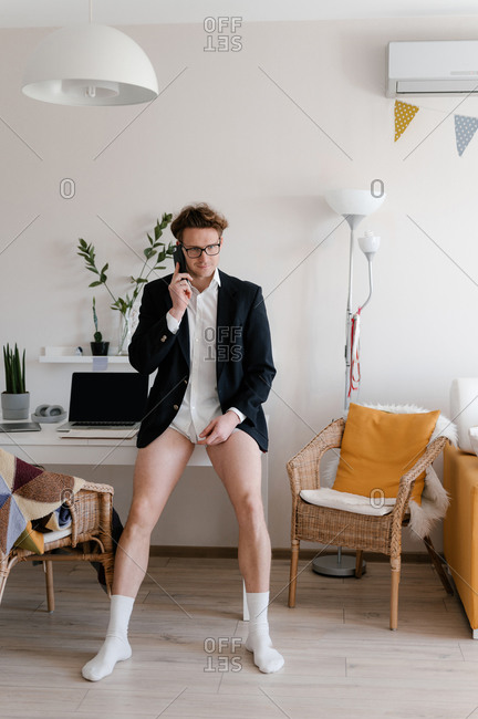 Man in underwear sitting indian style on floor with hands hovering