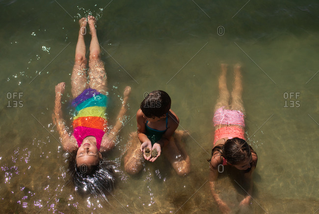 Three young girls playing in the water at the beach