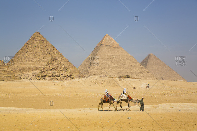 March 4, 2020: Tourists riding camels, Great Pyramids of Giza, UNESCO World Heritage Site, Giza, Egypt, North Africa, Africa