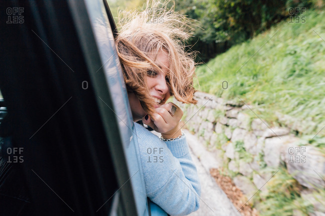 Woman turning around out of car window