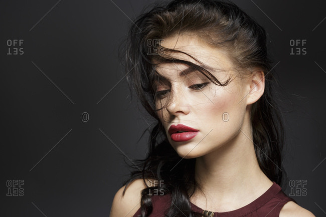 Beautiful young woman with long black flyaway hair, studio portrait