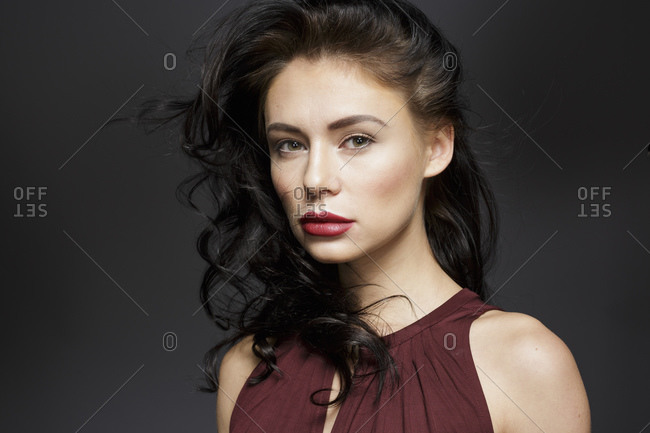 Beautiful young woman with long black hair, studio portrait