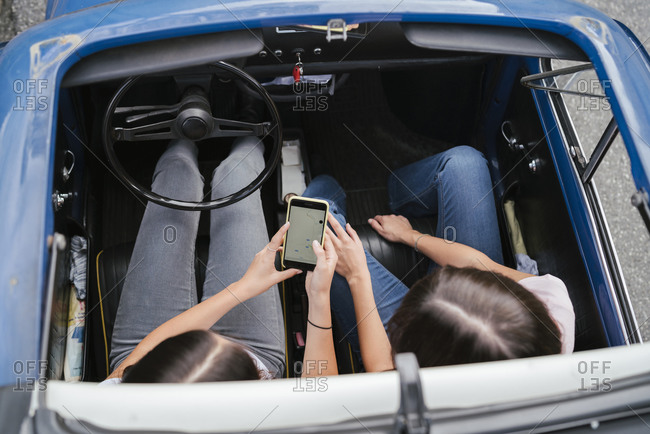 Friends using smartphone inside car