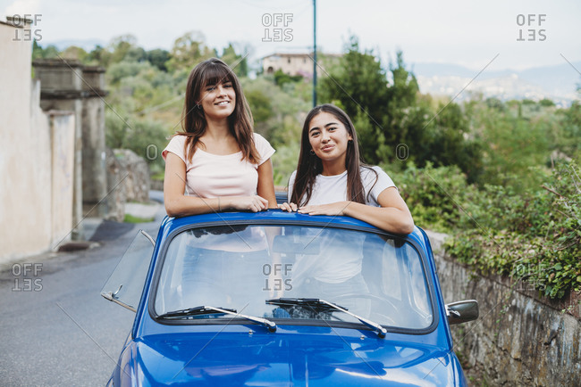 Friends posing in car sunroof, Florence, Toscana, Italy