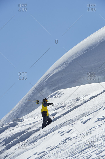 Skier walking up mountain, Saas-Fee, Valais, Switzerland