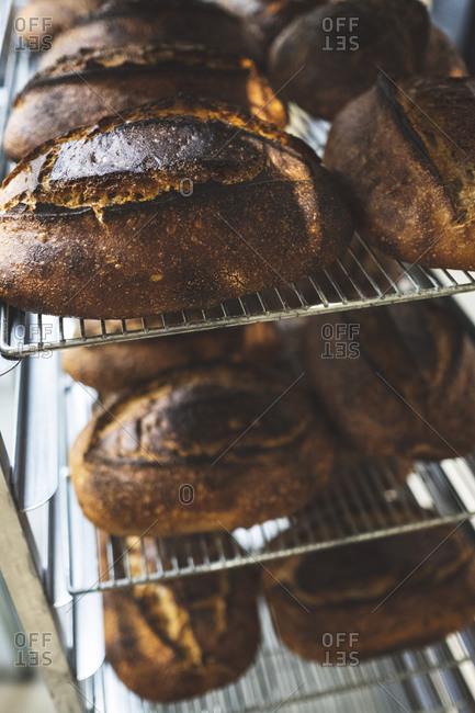 Artisan bakery making special sourdough bread, racks of baked bread with dark crusts.