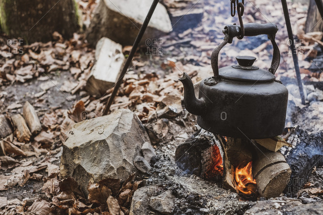 High angle close up of kettle over camp fire in a forest.