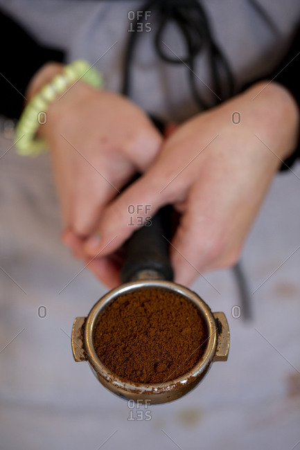 barista holding tamper above portafilter with grinded coffee, espresso, manual  press, arabica Stock Photo by LightFieldStudios