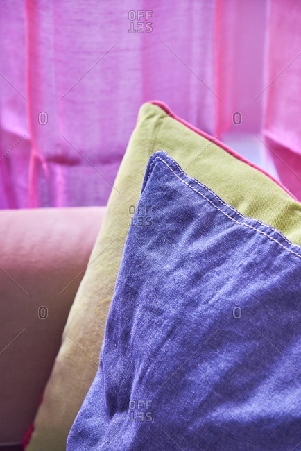 Colorful pillows on pink sofa