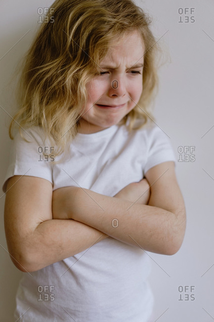 Annoyed little girl with curly hairs wearing gray cozy pajamas