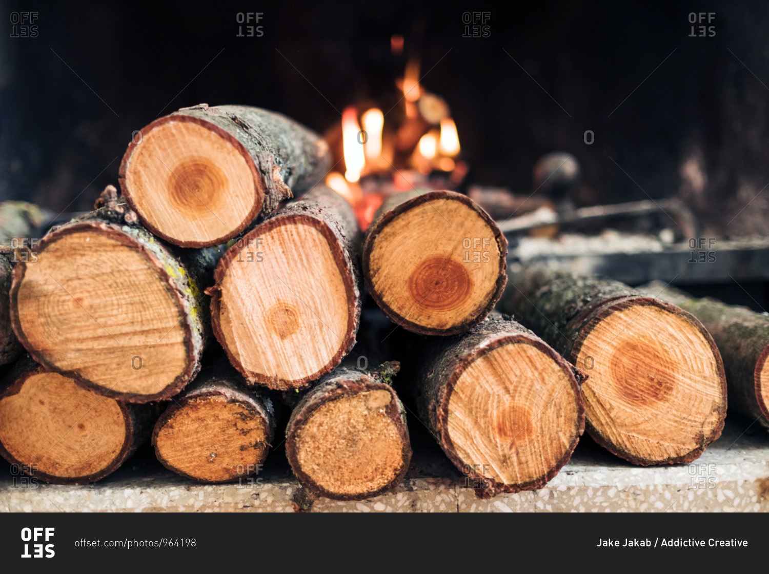 Closeup of fireplace with burning flame and firewood with smoke and ash