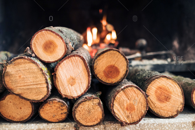 Closeup of fireplace with burning flame and firewood with smoke and ash