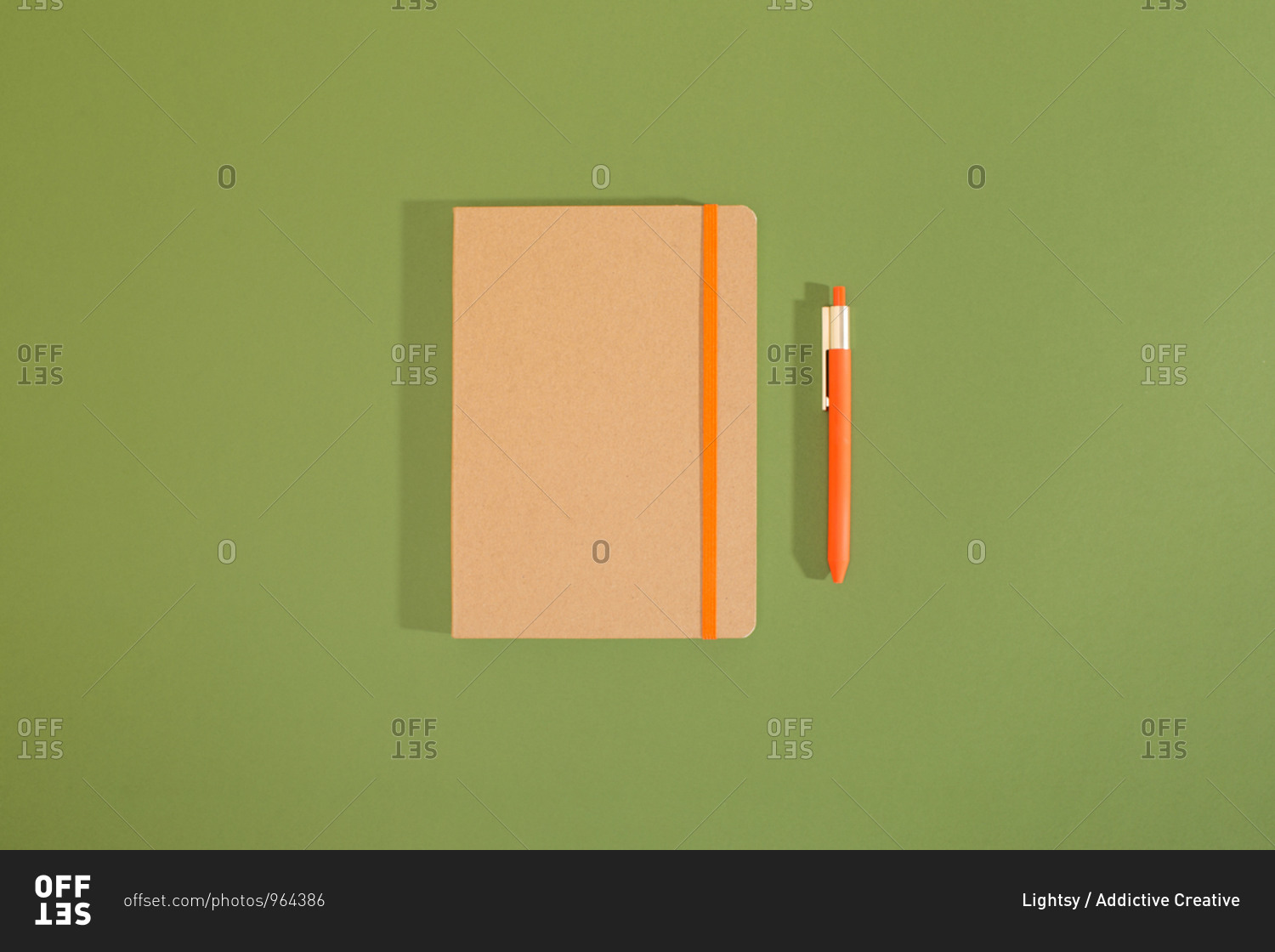 Top view of a minimal composition of recycled notebook and pencil with green background.