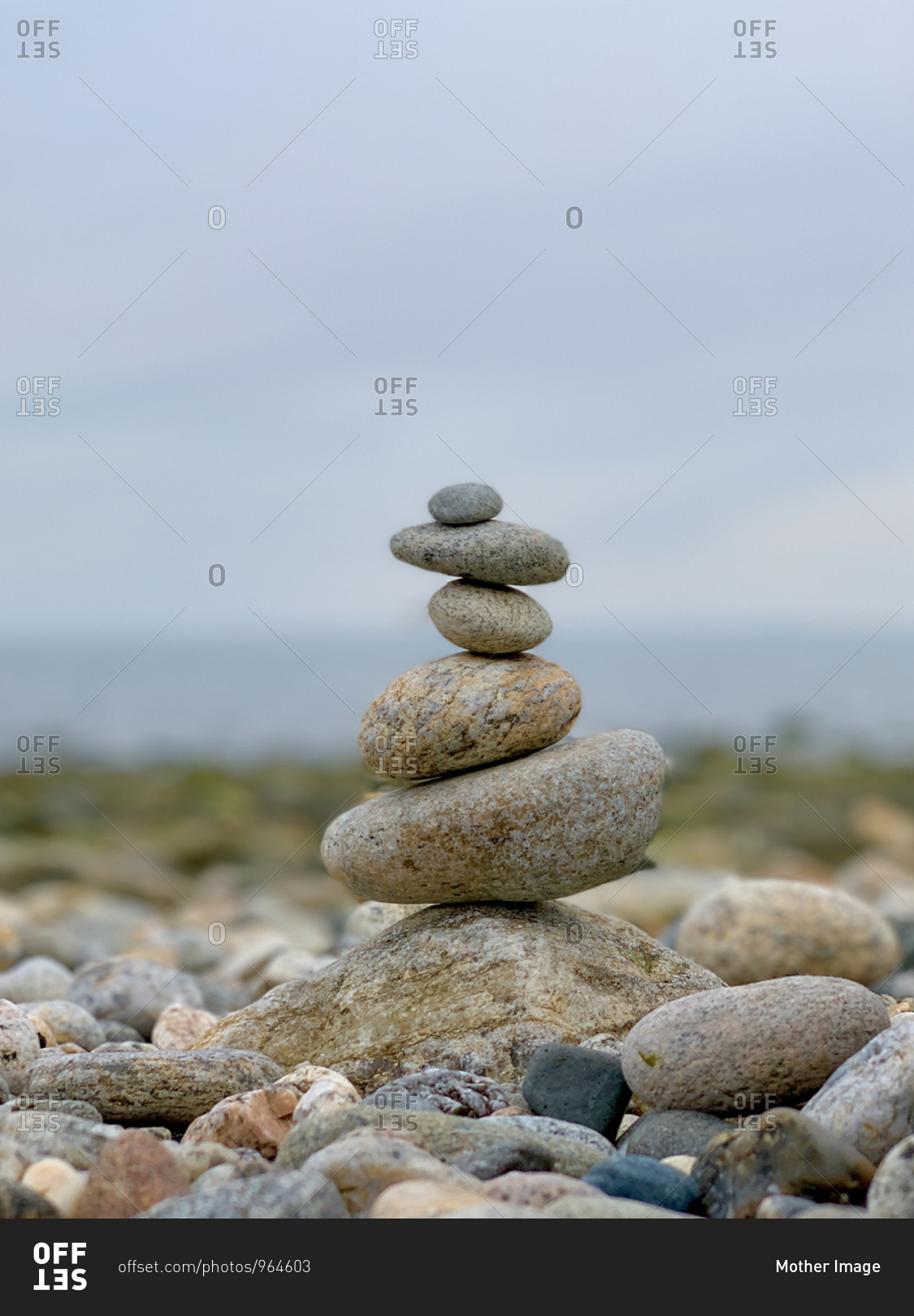 Delicately placed rocks on top of each other near coastline creating a serene and calm effect