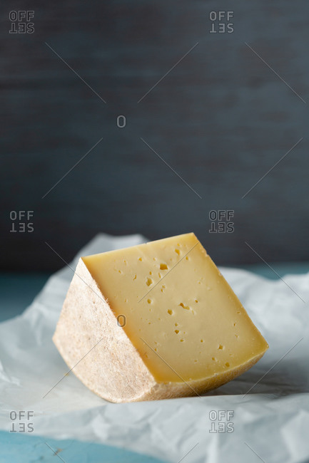 Close up of cheese on wax paper against gray wall