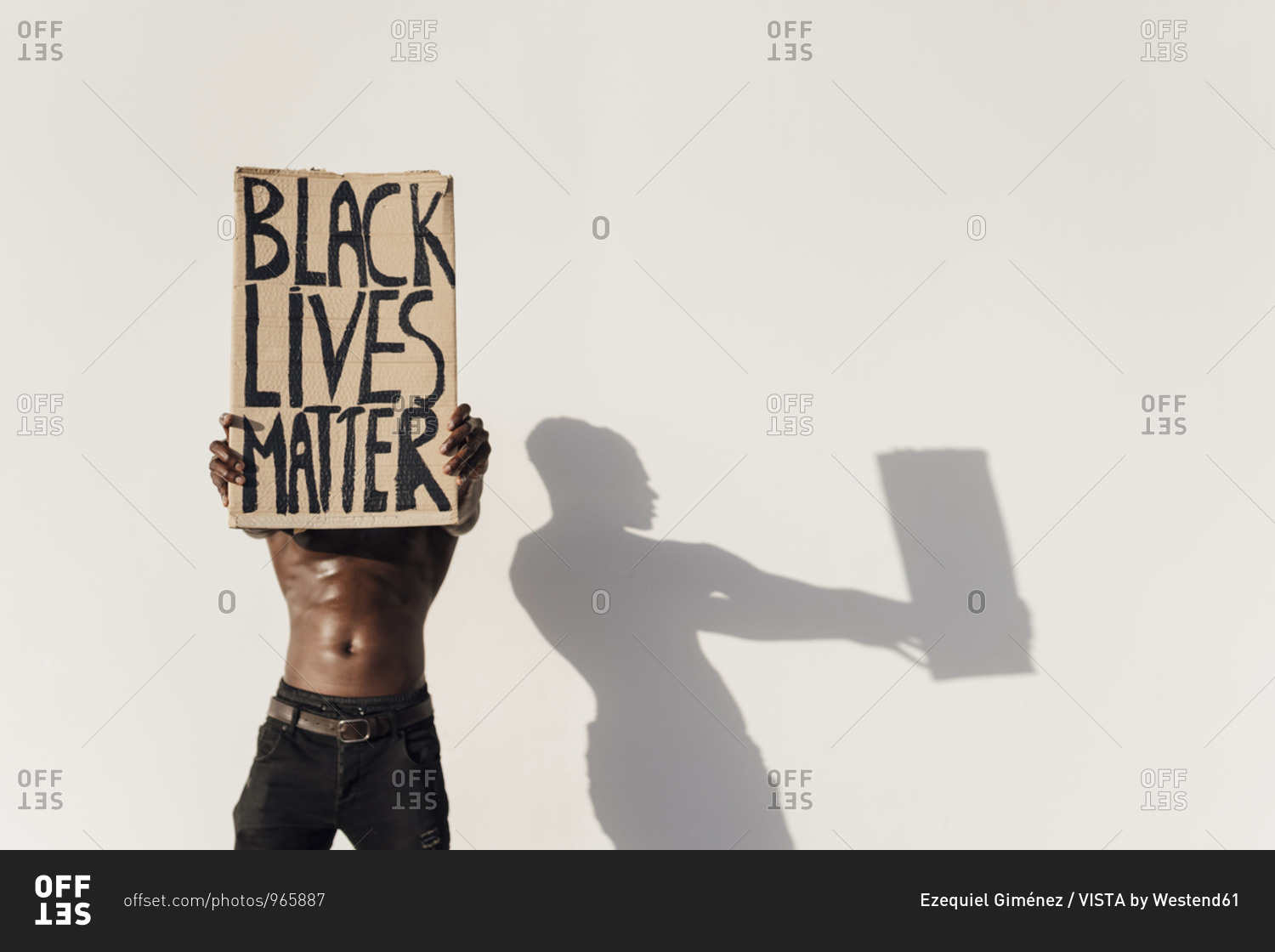 Man holding Black Lives Matter sign in front of his face
