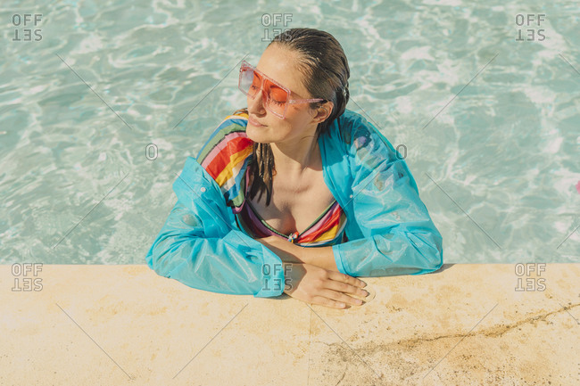 Portrait of dressed woman relaxing in swimming pool