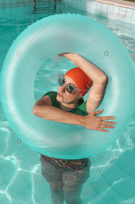 Portrait of woman with floating tire in swimming pool