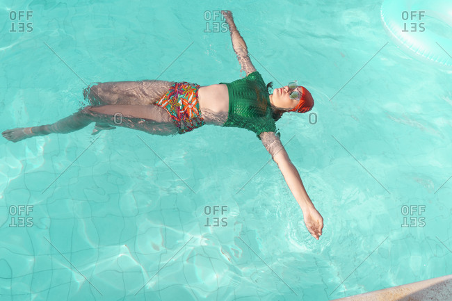 Woman floating on water in swimming pool