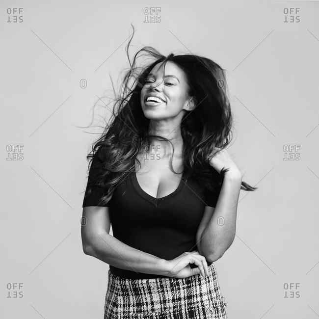 Black woman smiling as her hair blows in the wind