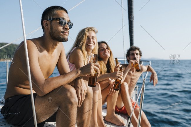 Friends enjoying beer on sailboat, Italy