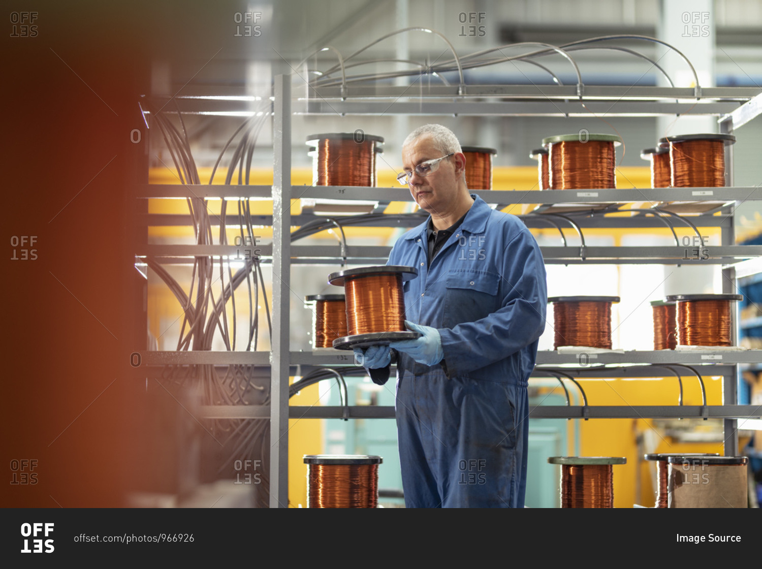 Electrical engineer with reel of copper wire in electrical\
engineering factory stock photo - OFFSET