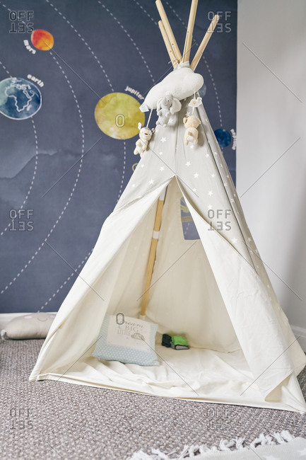 Child's teepee, mural of solar system on wall