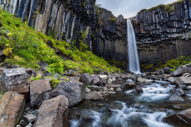 Svartifoss waterfall in autumn with watercourse in long term exposure, Skaftafell National Park, Iceland