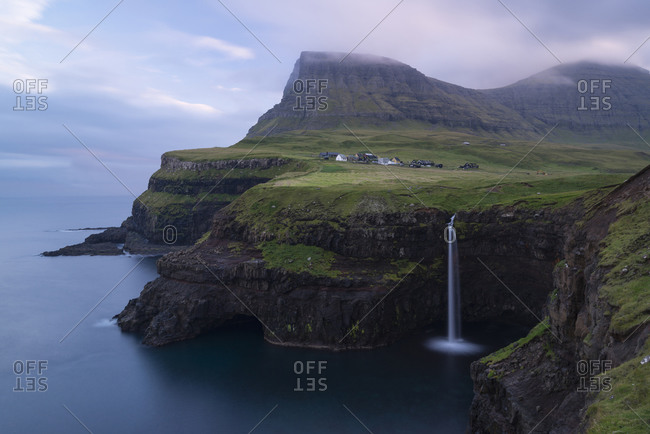 Dawn on the steep coast with waterfall in Gasadalur, Vagar, Faroe Islands, Denmark