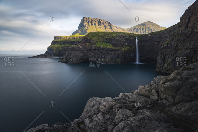Morning mood at the steep coast with waterfall in Gasadalur, Vagar, Faroe Islands, Denmark