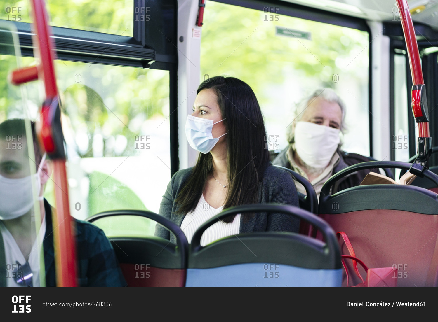 Woman wearing protective mask sitting in bus looking out of window- Spain