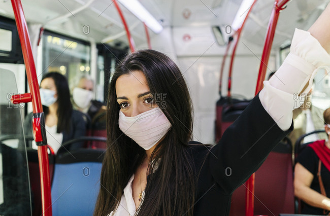 Portrait of young woman wearing protective mask in public bus- Spain