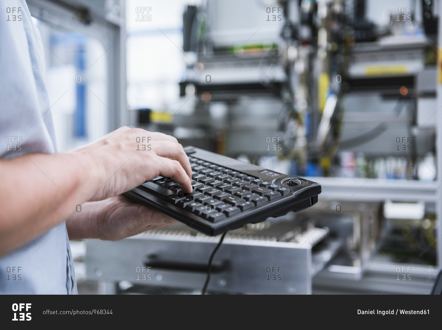 Close-up of man using keyboard in factory