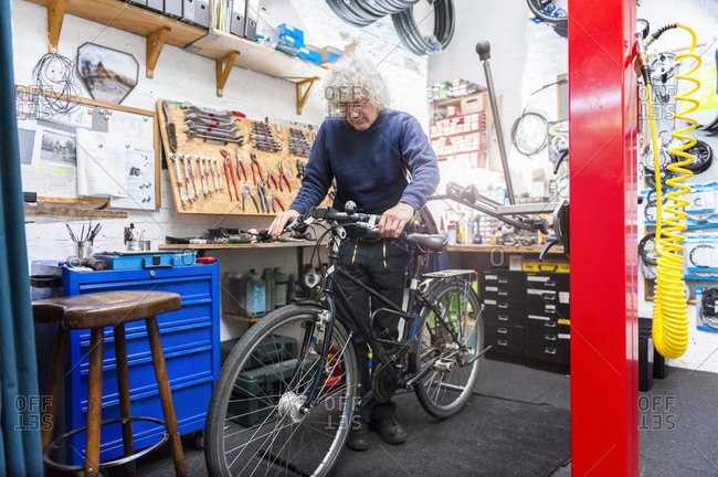 Bicycle mechanic working in bike shop- checking brake