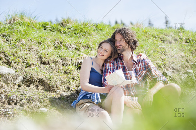 Hiking couple during break with map- Wallberg- Bavaria- Germany